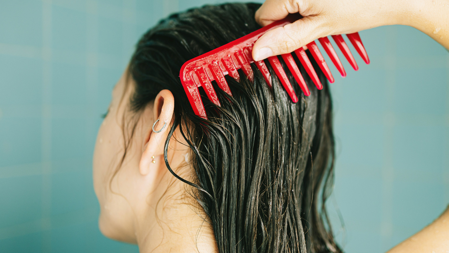 Woman With Brown Hair Brushing Out Dandruff In The Shower